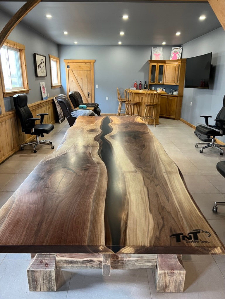 Conference table with epoxy centre, partly trimmed live edge and layered timber base