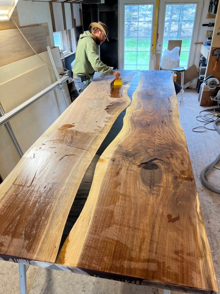 Applying a coating to the conference tabletop beside its epoxy centre